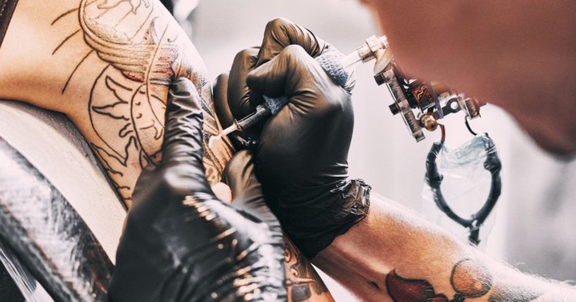 An undated file photo shows a tattoo artist at work.