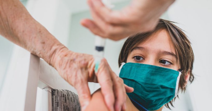 A little boy is vaccinated in the above stock image.