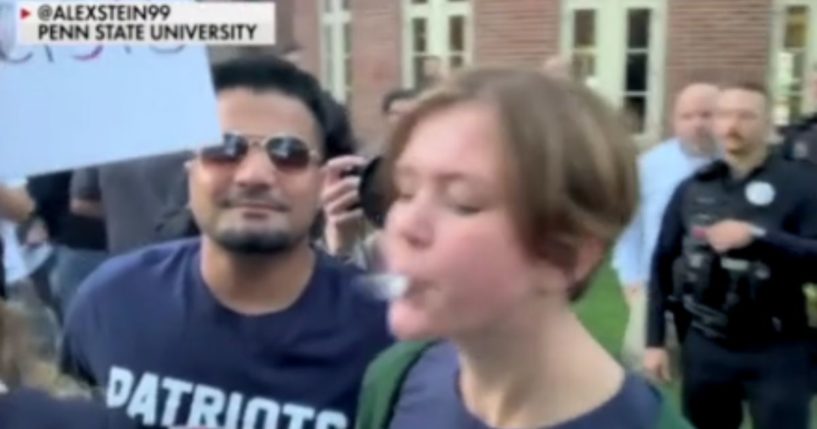 A Penn State student is pictured spitting on conservative comedian Alex Stein at an on-campus protest on Monday.