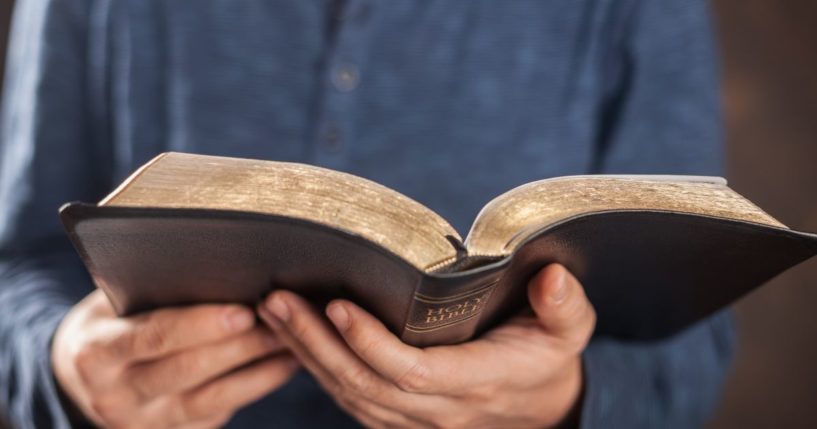 A man reads the Bible in this stock image.