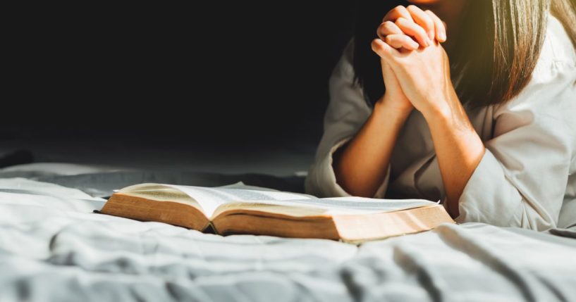 A woman reads the Bible in this stock image.