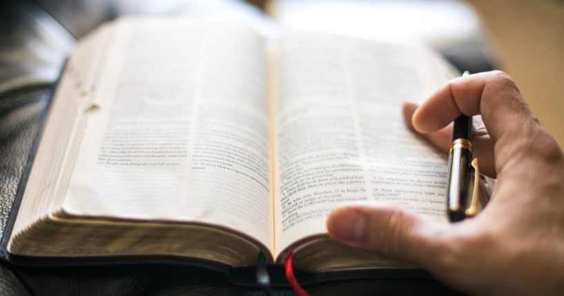 A man reads the Bible in the above stock image.