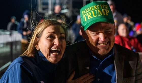 Iowa Gov Kim Reynolds laughs with her husband, Kevin, as former President Donald Trump speaks during a campaign event at the Sioux Gateway Airport in Sioux City, Iowa, on Nov. 3.