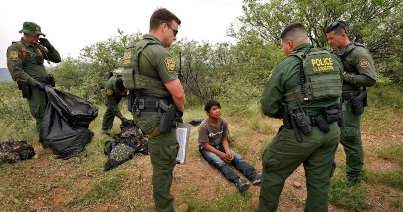 U.S. Border Patrol agents question a 12-year-old migrant boy after apprehension at the base of the Baboquivari Mountains near Sasabe, Arizona, on Sept. 8.