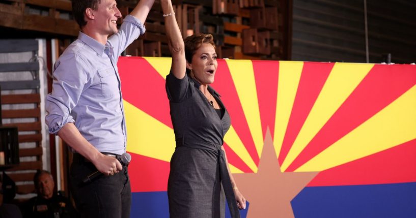 Arizona Republican gubernatorial candidate Kari Lake, right, and Arizona U.S. Senate candidate Blake Masters, left, raise their arms at a campaign rally in Queen Creek, Arizona, on Saturday.