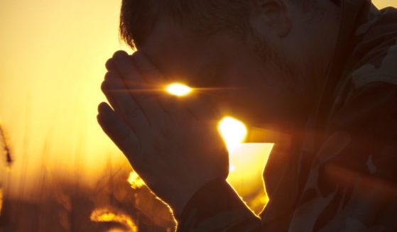 The above stock image is of a soldier praying.