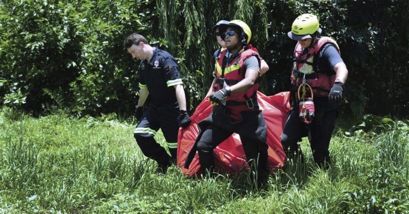 Rescuers carry the body of a flood victim that was retrieved from the Jukskei river in Johannesburg, South Africa, on Sunday.