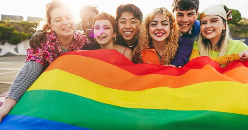 A group of minors hold the LGBT flag.