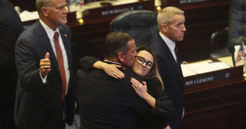 Florida Republican Rep. Bob Rommel of Naples, center, is hugged by Rep. Josie Tomkow of Polk City after his SB 2-A property insurance bill he co-sponsored passed Wednesday in the Florida House of Representatives. At left is Rep. Bobby Payne, R-Palatka; at right is House Speaker Paul Renner, R-Palm Coast. Florida lawmakers are meeting to consider ways to shore up the state's struggling home insurance market in the year's second special session devoted to the topic.