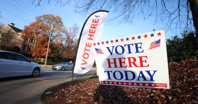 Signs are posted in front of a polling station on Nov. 26 in Dunwoody, Georgia.