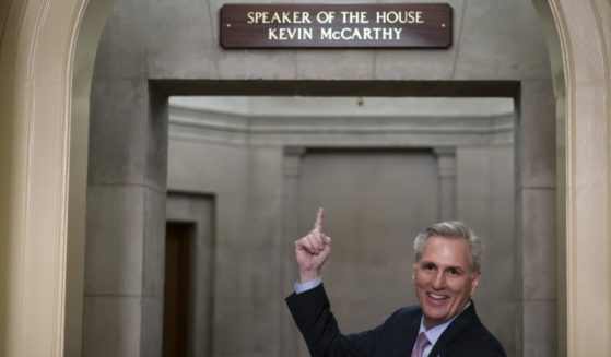 House Speaker Kevin McCarthy gesturing toward the newly installed nameplate at his office