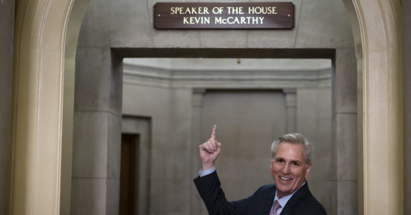 House Speaker Kevin McCarthy gesturing toward the newly installed nameplate at his office