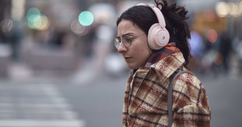 A woman using headphones walks in New York City on Tuesday.