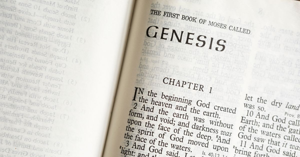 A Bible is open to the book of Genesis in this stock image.