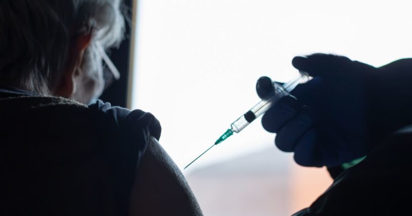 An elderly woman receives a vaccine in the above stock image.