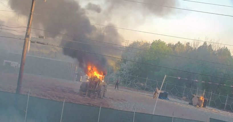 equipment burning after having been set on fire by violent protesters