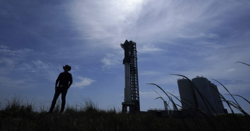 A man walks past SpaceX's Starship