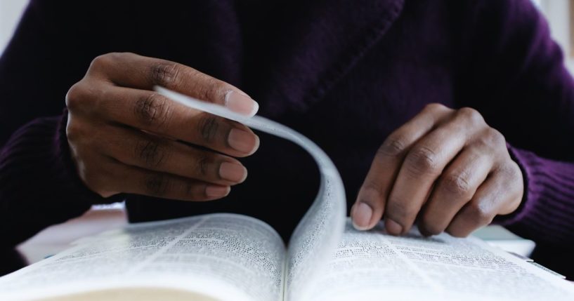 A woman reads the Bible in this stock image.