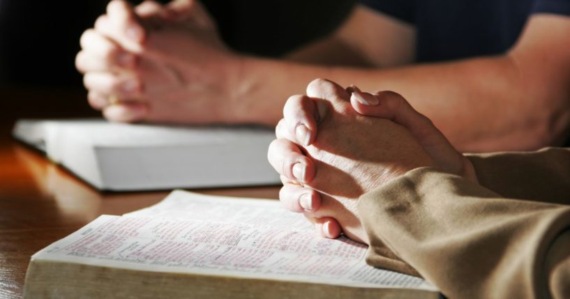 People pray in this stock image.