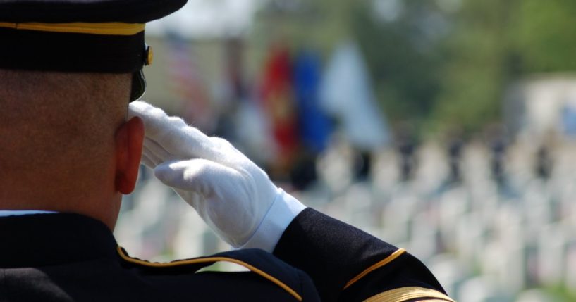 A service member salutes in this stock image.