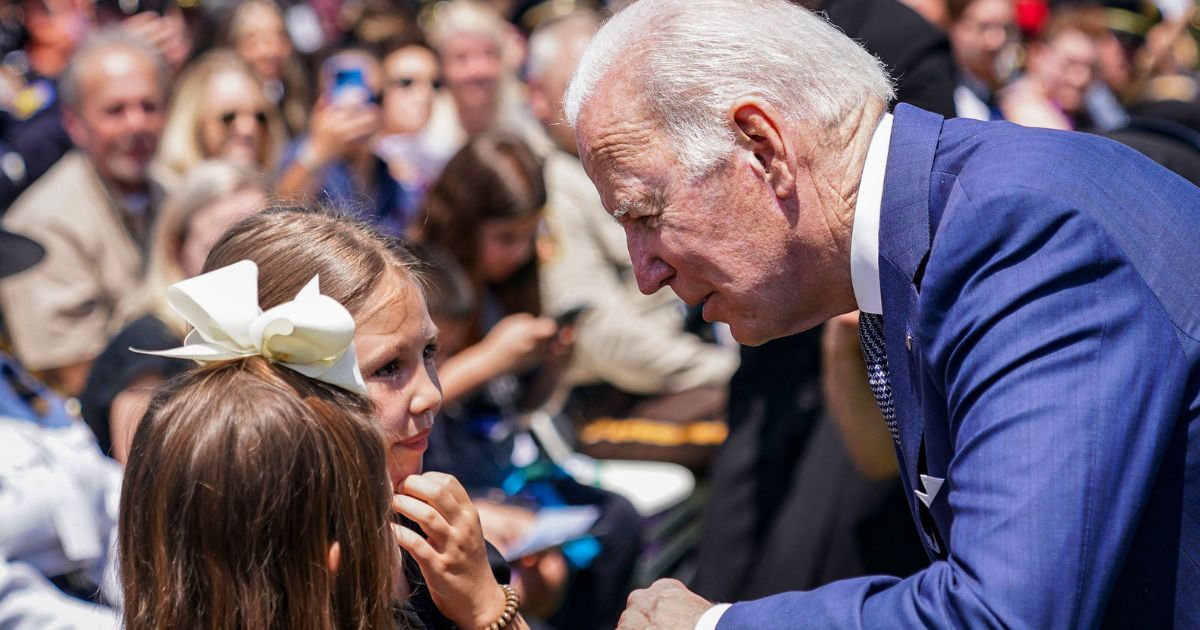 President Joe Biden talks to two girls after delivering remarks during the National Peace Officers Memorial Service at the U.S. Capitol in Washington, D.C., on May 15, 2022.