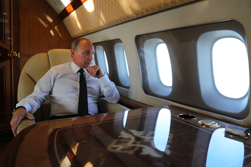 Russian President Vladimir Putin is pictured aboard the presidential plane in a file photo from December 2017. Putin's plane was reportedly seen taking off from Moscow Saturday, though officials insist he remains in the capital city and is working from the Kremlin.
