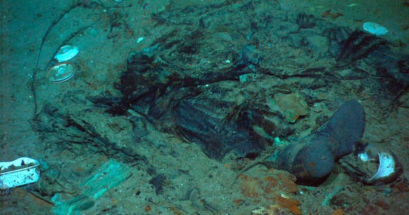 The remains of a coat and boots are seen in the mud on the sea bed near the Titanic's stern.