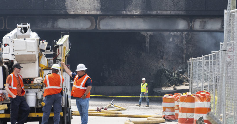 Officials work on the scene following a collapse on I-95 after a truck fire in Philadelphia on Sunday.