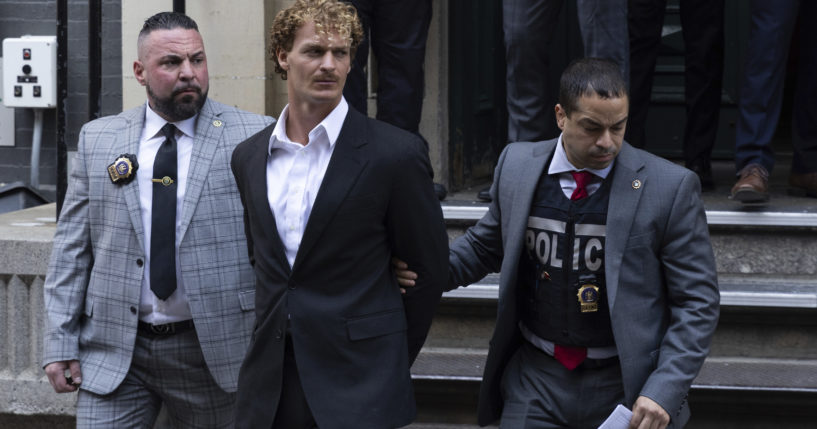 Daniel Penny, center, is walked by New York Police Department detectives out of the 5th Precinct in New York City on May. 12.