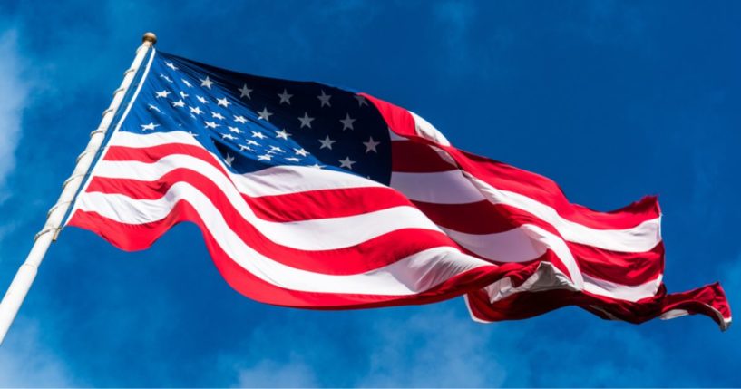 An American flag waves in the above stock image.