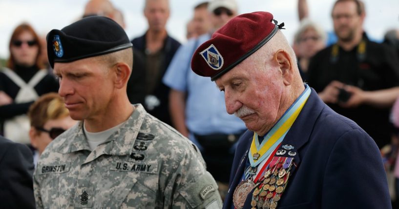 Command Sgt Major Retired Bill Ryan (R), who landed at Omaha Beach 70 years ago tomorrow, with current Division Sgt. Major Michael Grinston (L) during a moment of silence for fallen colleagues at a ceremony honoring the First Infantry Division's actions on D-Day on Omaha Beach June 5, 2014, in Colleville-sur-Mer, France.