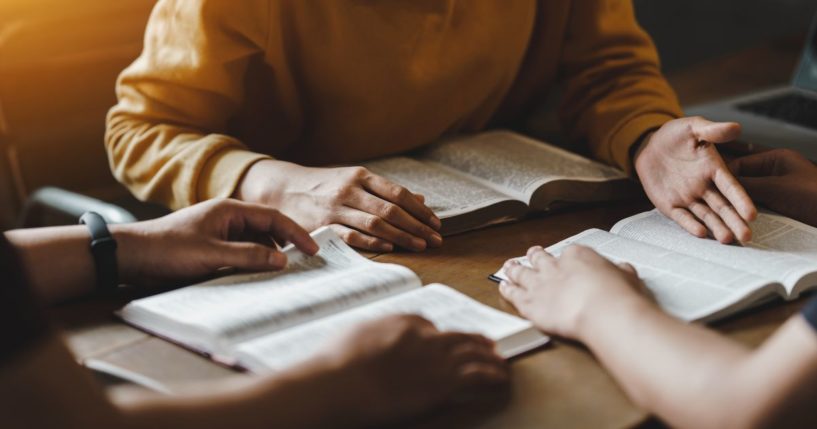 This stock photo shows a group doing a Bible study together.