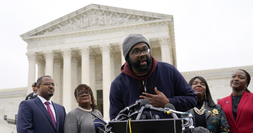 Evan Milligan, center, plaintiff in Merrill v. Milligan, an Alabama redistricting case that could have far-reaching effects on voting, speaks with reporters at the Supreme Court in Washington, October 4, 2022.