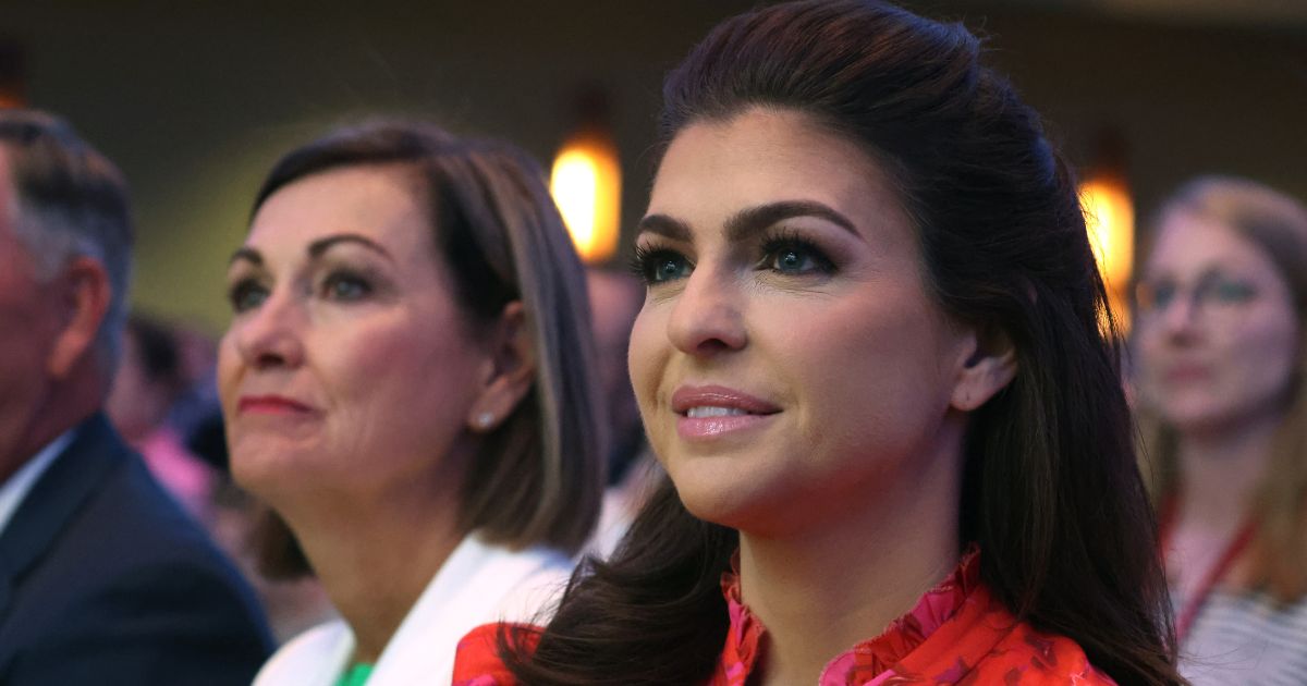 Iowa Governor Kim Reynolds (L) and Casey DeSantis, the wife of Florida Governor Ron DeSantis, listen as Ron DeSantis speaks at the Family Leadership Summit on Friday in Des Moines, Iowa.