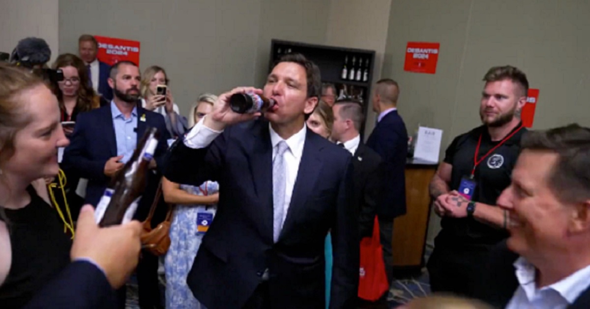 Florida Gov. Ron DeSantis enjoys a beer with supporters Friday after a speech in Iowa.