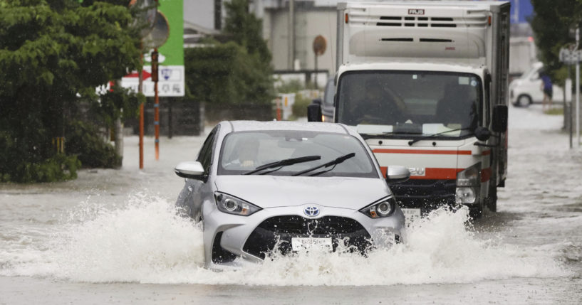 Cars plow through high water on a street in southern Japan.