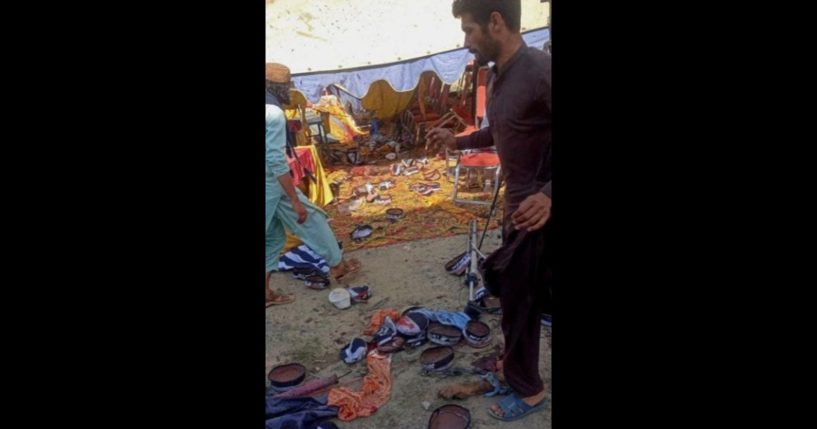 Men gather at the site of a bomb blast in Bajaur district on July 30, 2023. At least 16 people were killed and dozens more wounded on July 30 by a bomb blast at a political gathering of a radical Islamic party in northern Pakistan, police said.