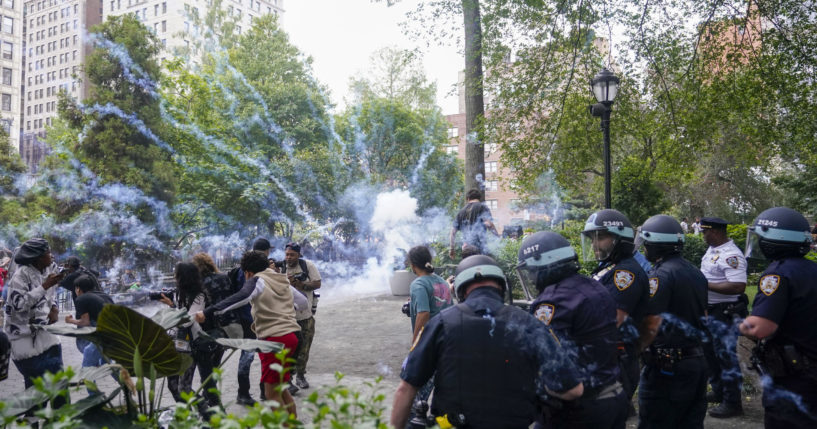 Police officers set off a smoke bomb in order to disperse a mob on Friday in New York's Union Square.