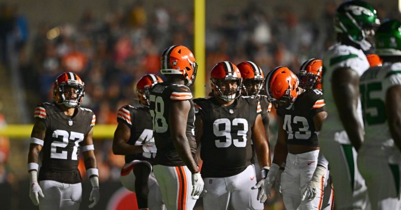 Players from the Cleveland Browns and New York Jets mill about after several banks of stadium lights went out during the second half of the Hall of Fame preseason game Thursday night in Canton, Ohio.