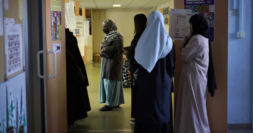 Women wait in line before voting for the first round of the presidential election at a polling station Sunday, April 10, 2022 in the Malpasse northern district of Marseille, southern France.