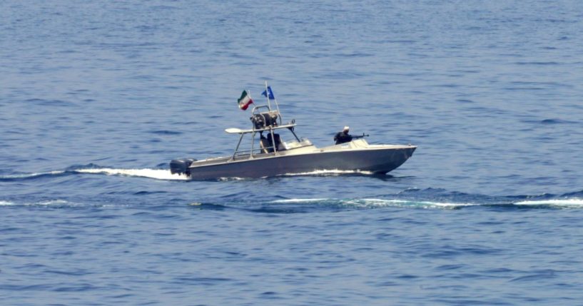 An Iranian Revolutionary Guard vessel watches an American warship in the Strait of Hormuz on May 19.