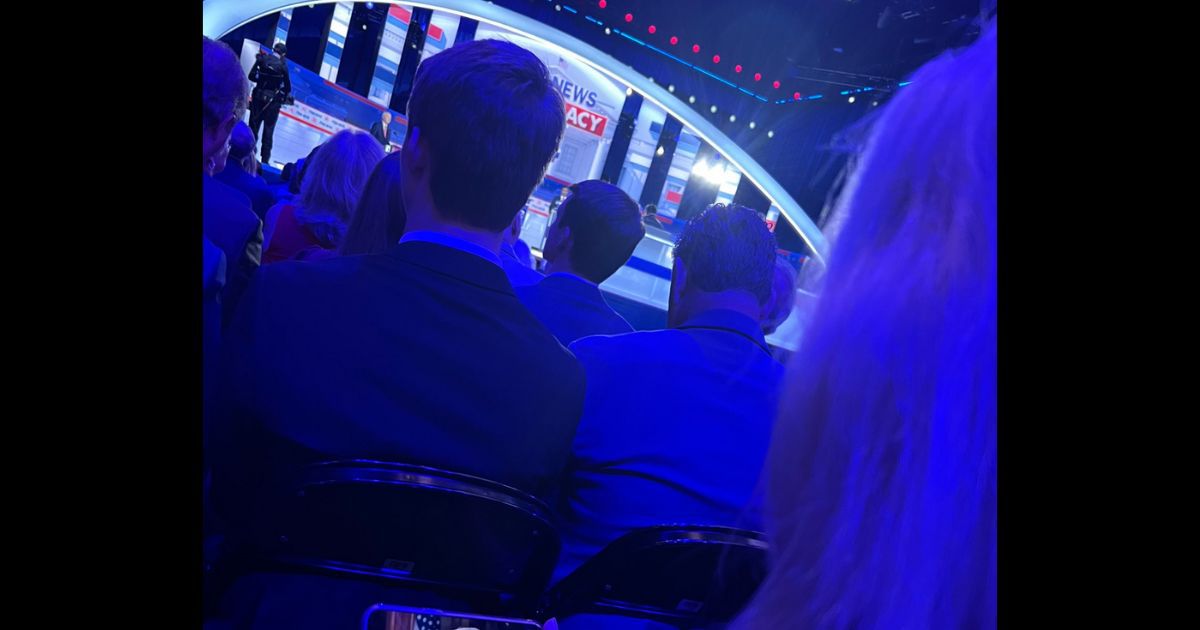 A camera behind Rep. Marjorie Taylor Greene, pictured on the right, showed what she was doing on her phone during the GOP presidential debate.