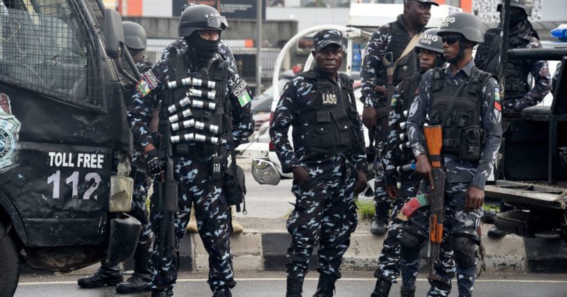 Police officers stand as supporters march to campaign for candidate of Labour Party Peter Obi during a campaign rally in Lagos, on Oct. 1, 2022.