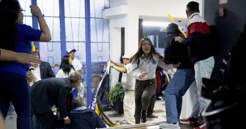 People take cover after shots were fired at the end of a rally with Ecuadorian presidential candidate Fernando Villavicencio in Quito on Wednesday.