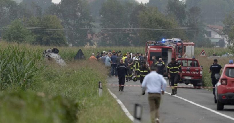 Car debris is seen at left as firefighters seal off the area where an aircraft of an Italian acrobatic air team crashed during a practice run outside of Turin, Italy, on Saturday.