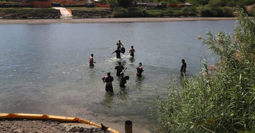 A group of undocumented immigrants wade across the Rio Grande at the U.S.-Mexico border on March 14, 2017, in Roma, Texas.