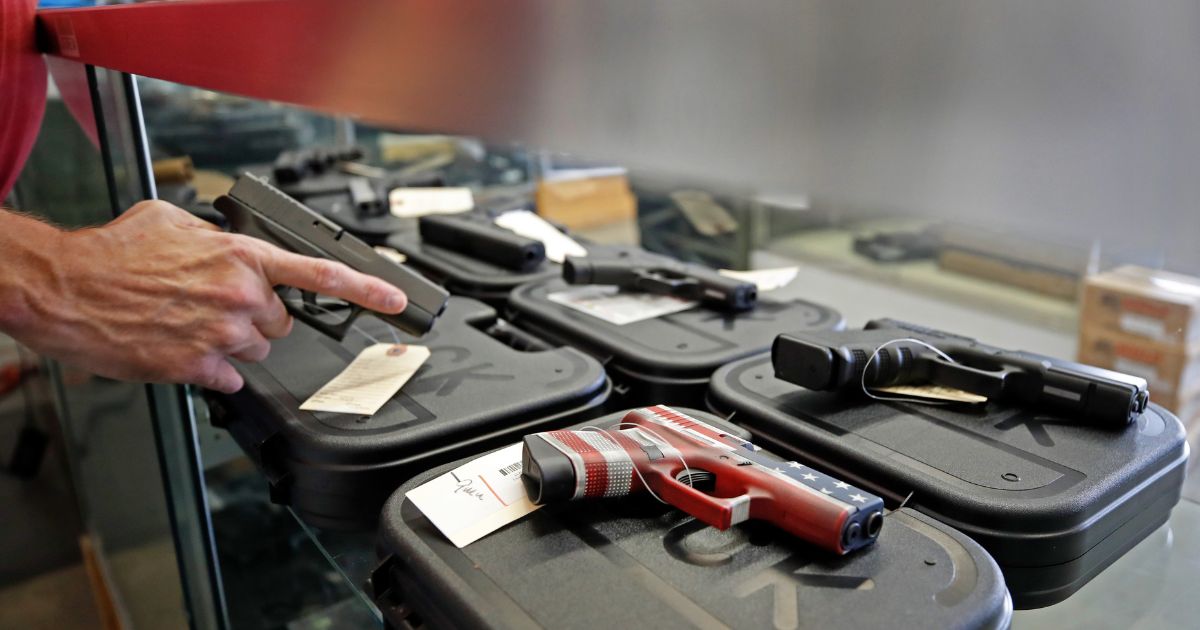 A worker restocks handguns at Davidson Defense in Orem, Utah on March 20, 2020.