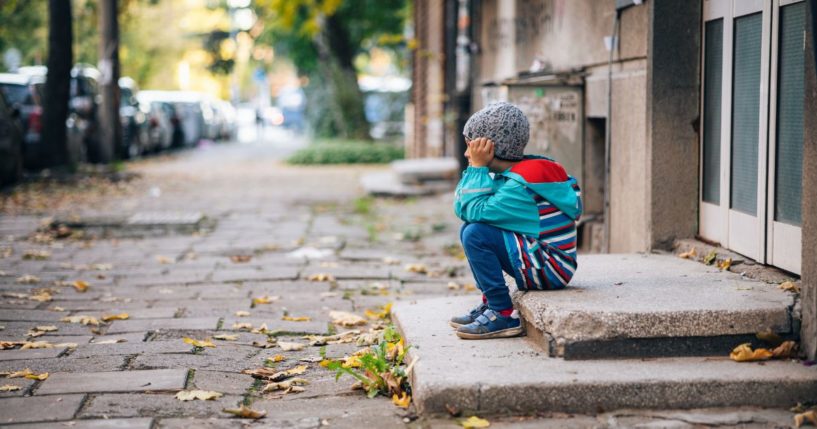 The above stock image is of a child sitting on steps.