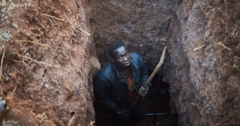 A gold miner poses for a portrait inside his trench at a gold mining site in Zvishavane, Zimbabwe, on Aug. 22.