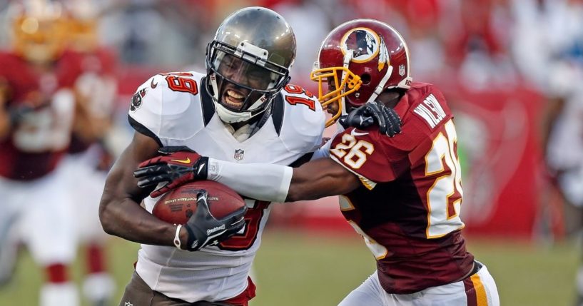 Receiver Mike Williams #19 of the Tampa Bay Buccaneers is tackled by defender Josh Wilson #26 of the Washington Redskins during the game at Raymond James Stadium on Sept. 30, 2012, in Tampa, Florida.